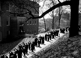 A procession of men walking on campus as part of Manhattan’s centennial anniversary.